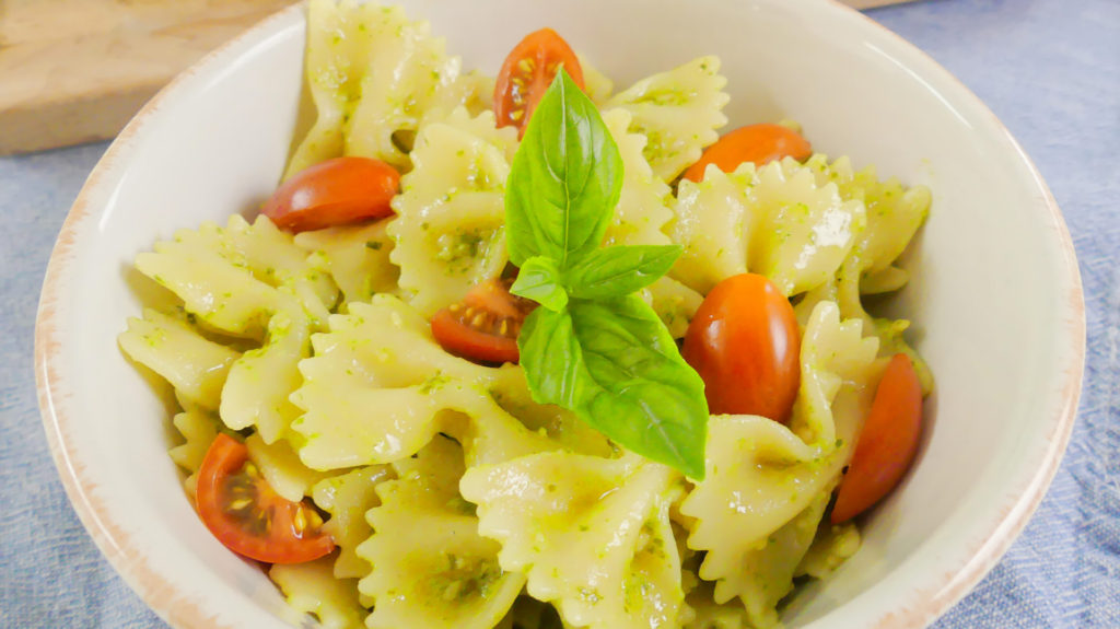 pesto sauce on pasta with tomatoes and basil