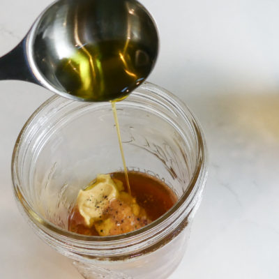 tablespoon of olive oil poured into a mason jar