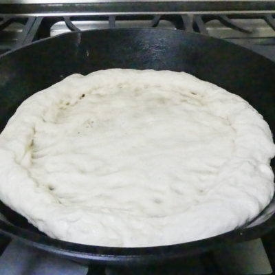 homemade pizza dough in a cast iron skillet