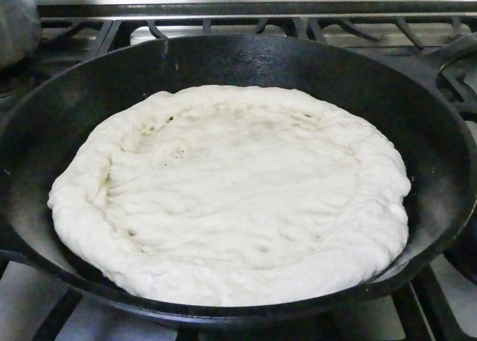 homemade pizza dough in a cast iron skillet