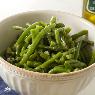 green beans in a bowl with olive oil and garlic