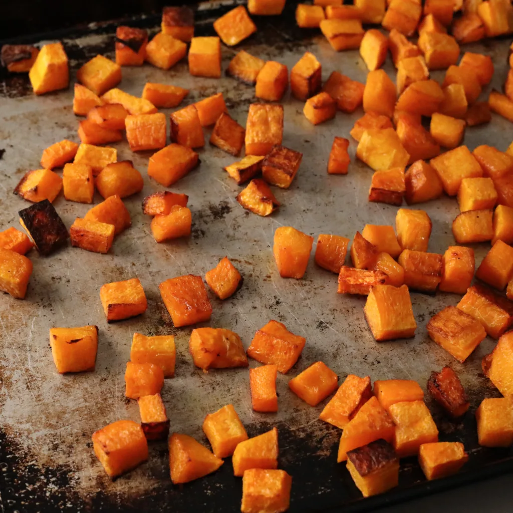 roasted butternut squash cubes on a baking sheet