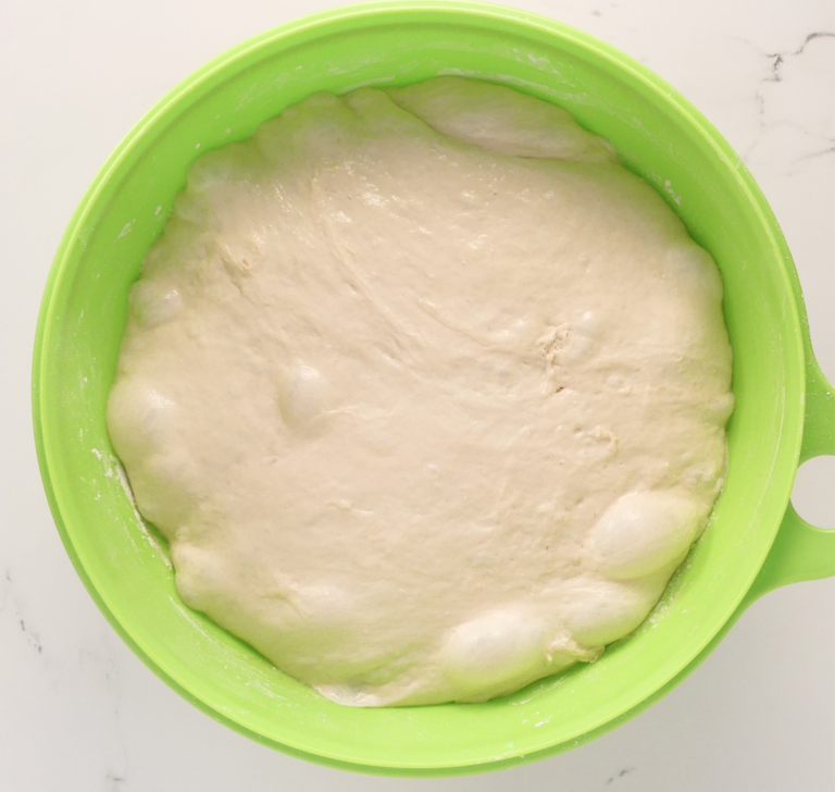 pizza dough in a green bowl